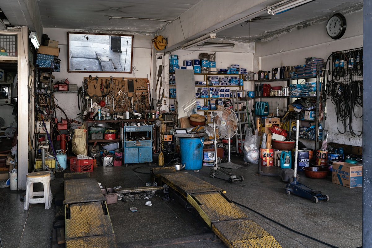 The inside of a well-used independent garage, tools and parts lining every wall